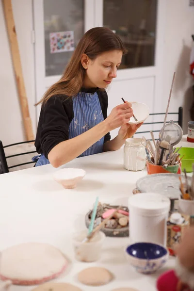 陶瓷室女性艺术家装饰陶瓷碗的垂直照片 — 图库照片