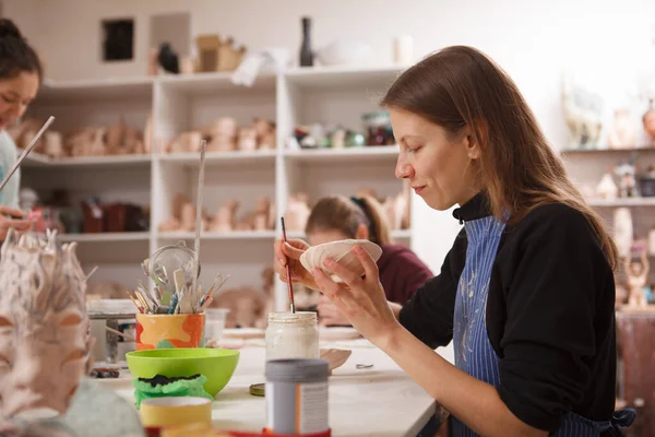 Kobieta Zdobiąca Ceramiczną Miskę Ciesząca Się Pracą Pracowni Garncarskiej Przestrzeń — Zdjęcie stockowe