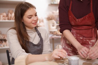 Sanat okulunda çömlekçilik öğrenen hoş bir genç kadın.