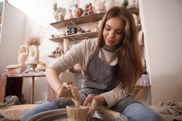 在工艺工作室用陶瓷轮与粘土一起工作的漂亮女人的低角度镜头 — 图库照片