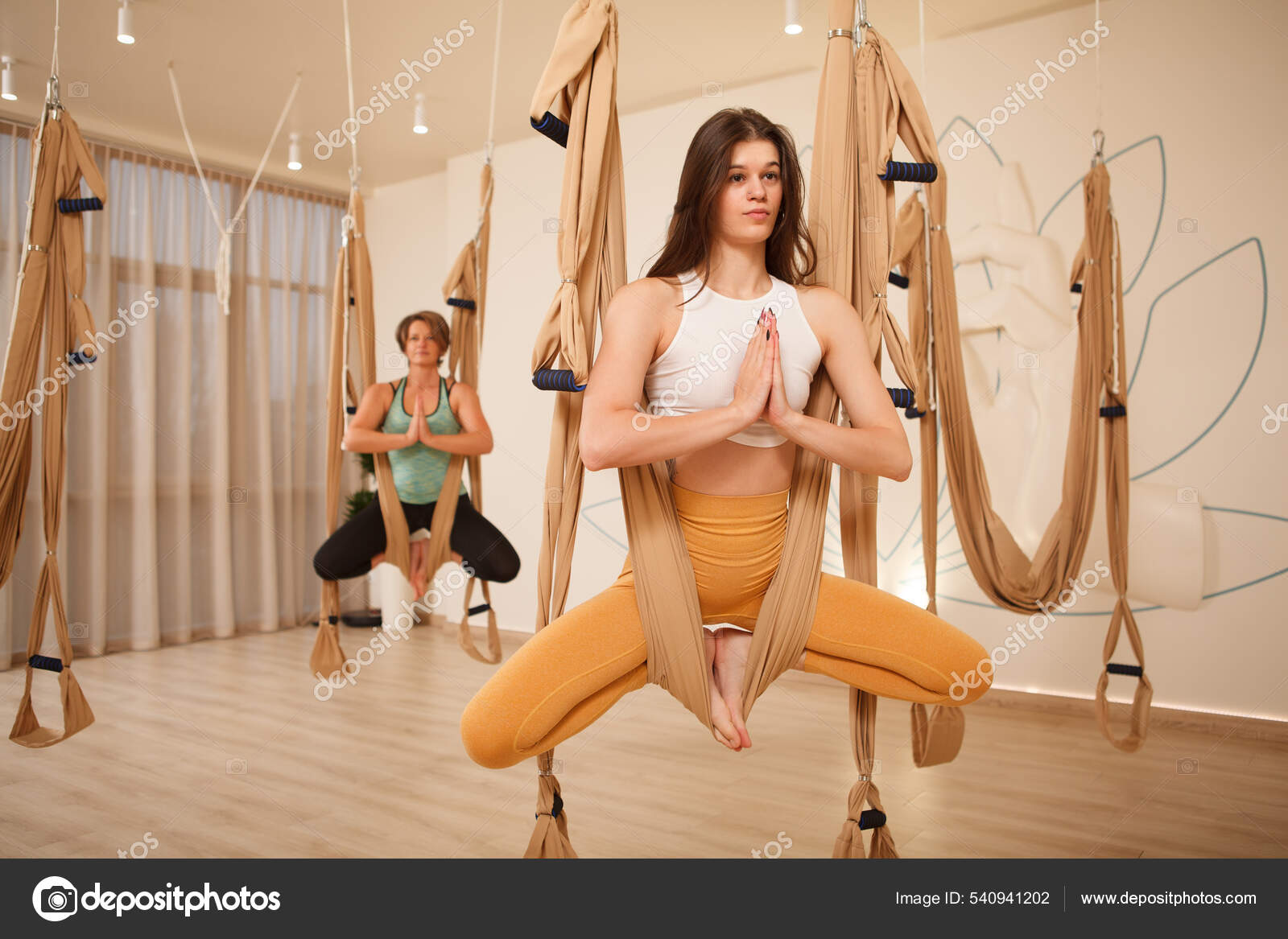 Women Doing Gravity Pigeon Pose Fly Yoga Studio Using Aerial Stock