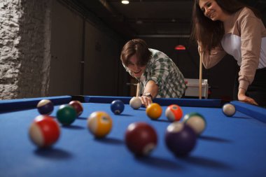 Gençler bilardo oynarken eğleniyorlar.