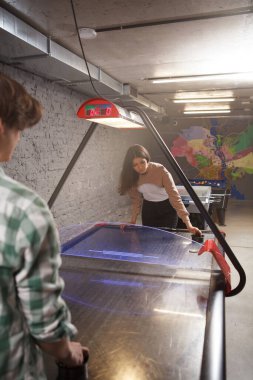 Hava hokeyi oynayan genç bir çiftin dikey çekimi.