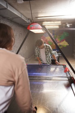 Gençlerin hokey masasında eğlenirken dikey çekimleri.