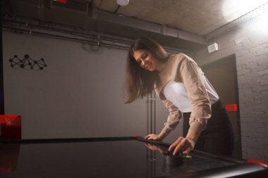 Çekici kadın hava hokeyi oynarken eğleniyor.