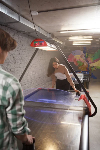 Hava hokeyi oynayan genç bir çiftin dikey çekimi.