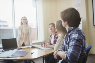 Erkek öğrenci rahat oturuyor, üniversite öğretmeniyle seminerden keyif alıyor, kopya alanı.