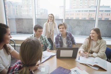 Üniversite öğrencileriyle aynı sınıfta olan kadın profesör.