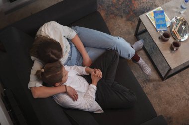 Bir annenin genç oğluna sarılıp, birlikte kanepede oturduğu en iyi görüntü.