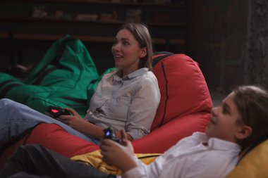 Anne ve oğlu birlikte video oyunu oynuyorlar.