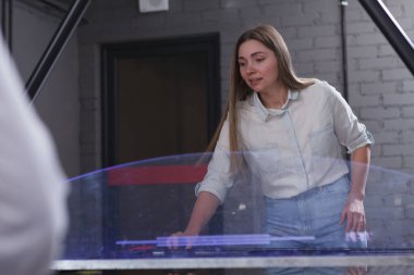 Hava hokeyi oynayan çekici bir kadın, odaklanmış görünüyor.