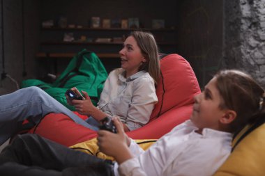 Mutlu anne ve oğul odaklanmış görünüyor, video oyunları oynuyorlar.