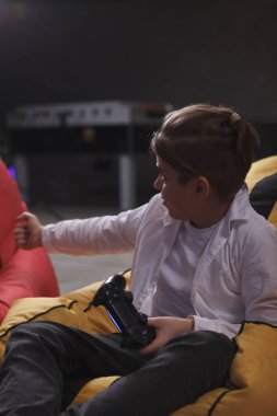 Oyun oynayan, joystick konsolu kullanan bir çocuğun dikey görüntüsü.