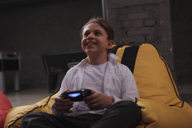 Oyun konsolu kullanan mutlu çocuk, video oyunları oynuyor