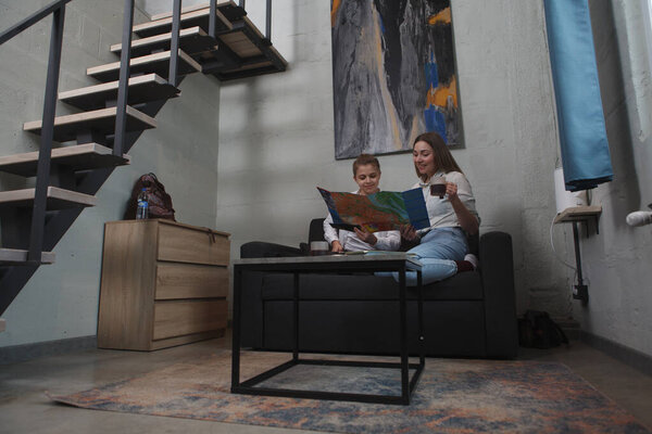 Full length shot of a young woman and her son examining city map, planning sightseeing tour