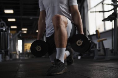 Bir sporcunun spor salonunda ağır hamleler yaparken görüntüsü.