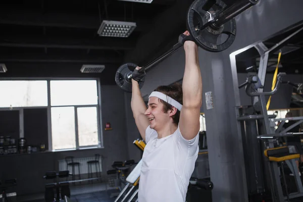 Young Athletic Man Lifting Barbel Overhead Exercising Gym — Foto Stock