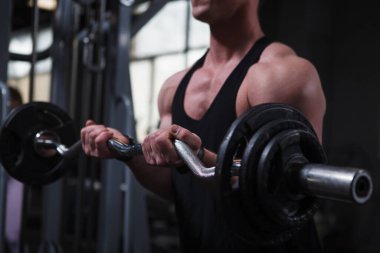 Cropped shot of a muscular bodybuilder training with ez curl bar