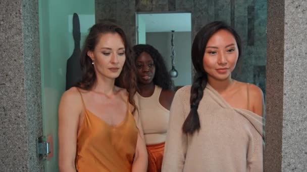 ヨーロッパ アジア アフリカの3人の若い女の子が驚きの感情を持って部屋に入ります — ストック動画
