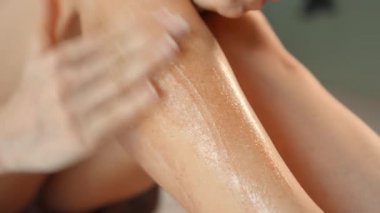 Elleriyle krem süren genç bir kızın bacakları nazikçe tenine sürtünüyor.