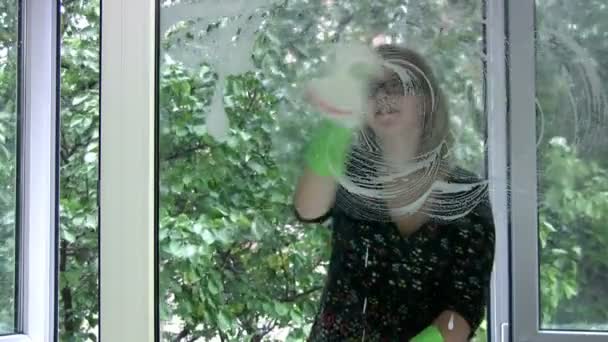 Girl washing window — Stockvideo