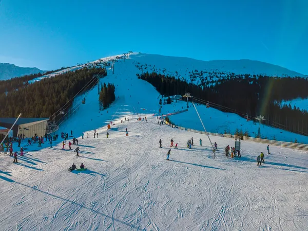 斯洛伐克 冬天是阳光明媚的日子 森林群山中的滑雪斜坡 蓝天和太阳明亮地照耀着 空中景观 — 图库照片
