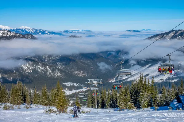 斯洛伐克滑雪胜地Jasna 雪在阳光下闪闪发光 蓝天和薄雾夹在山巅之间 滑雪者和滑雪者 — 图库照片