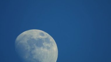 Koyu mavi bulutsuz gökyüzü. Ay çok yakında hareket ediyor. Ay 'ın gözle görülür yardımı