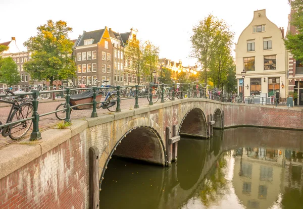 Nizozemsko Kamenný Most Třemi Oblouky Amsterdamském Kanálu Spousta Zaparkovaných Kol — Stock fotografie