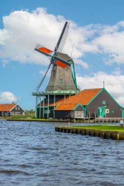 Netherlands. Summer day in Zaanse Schans. Dutch windmill on the bank of the canal