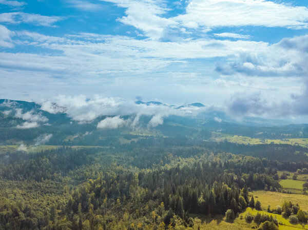 Ukraine. Sunny summer day in the Carpathians. Diverse clouds over a wooded valley