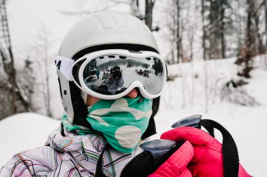 Kayak yapıyorum. Karlı dağlarda iyi kayak. Karpatya 'da kar üzerinde kar maskeli bir kadın. Orman ve kayak yamaçlarının arka planında. Kapatın. Kış doğası. Güzel bir kış günü..