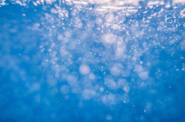 Suyun altında. Okyanustaki su altı turkuaz dokusu. Tropikal denizde kabarcıklar. Yüzme havuzunda mavi mahsul su. Havuzda Bokeh lambası var. Yaz dönemi. Yan görünüm.