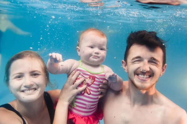 娘と父は 水泳のレッスンで泳ぐことを学びます 物理的な演習を行います プールで水中で潜水 健康的なライフスタイル積極的な親 水泳や泡の楽しみ — ストック写真