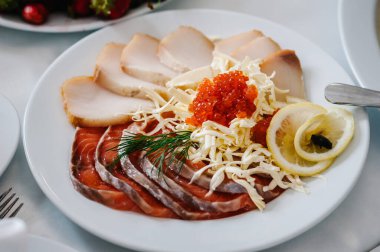 Bulaşık. Kırmızı havyar ve balık. Ton balığı. Masada beyaz tabak var. Yiyecekler. Tatil yemeği. Düğün günü..