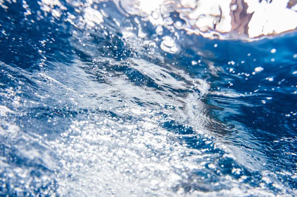 Suyun altında. Okyanustaki su altı turkuaz dokusu. Tropikal denizde kabarcıklar. Yüzme havuzunda mavi mahsul su. Havuzda Bokeh lambası var. Yaz dönemi. Yan görünüm.