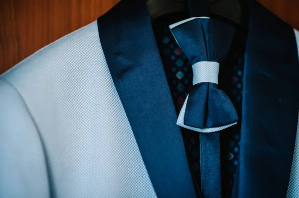 Een Mannenjasje Blauw Pak Met Vlinderdas Aan Een Hanger Kamer — Stockfoto