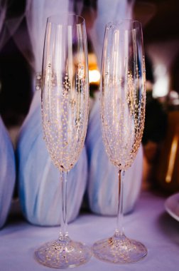 Gelin ve damat için arka planda iki kadeh şampanya. Bokeh ve parlak ışık.