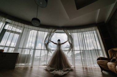 Gelinin arkadan görünüşü, gelinin sabahının romantik atmosferi. Şık bir gelinlik..