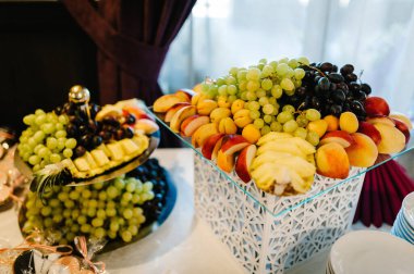 Meyveli tabak. Parti için dekore edilmiş tatlı masası. Taze, egzotik, organik meyveler, açık büfede hafif atıştırmalıklar..
