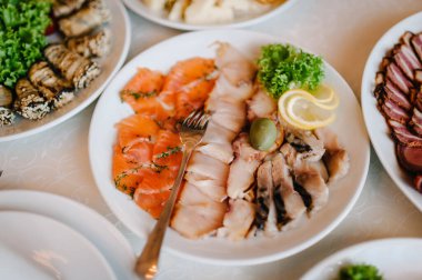 Bulaşık. Kırmızı havyar ve balık. Ton balığı. Beyaz masada beyaz tabak. Yiyecekler. Balık yumurtası, zeytin. Tatil yemeği. Düğün günü..