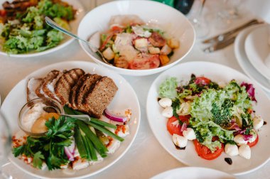 Şenlik masasında yemek servisi yapıyor. Yemek, salata, et, balık menüsü. Düğün ziyafetinde şölen masası. Dekorasyon. Ayrıntılar. Üst görünüm.