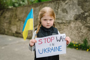 Portrait little child calls no war, raises banner with inscription Stop war in Ukraine and blue-yellow flag of Ukraine. Peace, stop russian aggression. United Europe against Russia. Hope for world