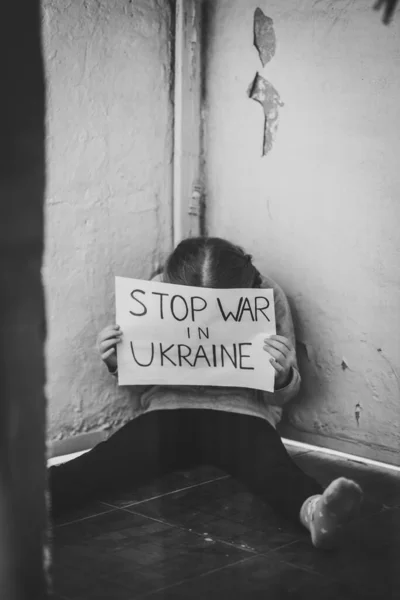 전쟁에 반대하는 소녀는 우크라이나 전쟁을 한다는 문구가 현수막을 무너진 바닥에 — 스톡 사진