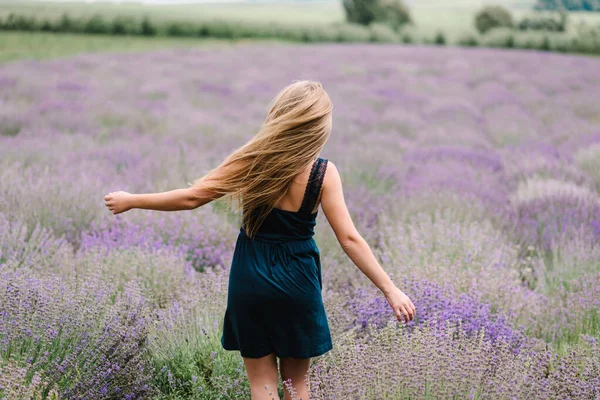 穿着连衣裙 长发飘扬在紫色薰衣草地里的漂亮姑娘 日落时 美丽的女人在薰衣草地里散步 尽情欣赏花香 享受夏日的自然 背景色 — 图库照片