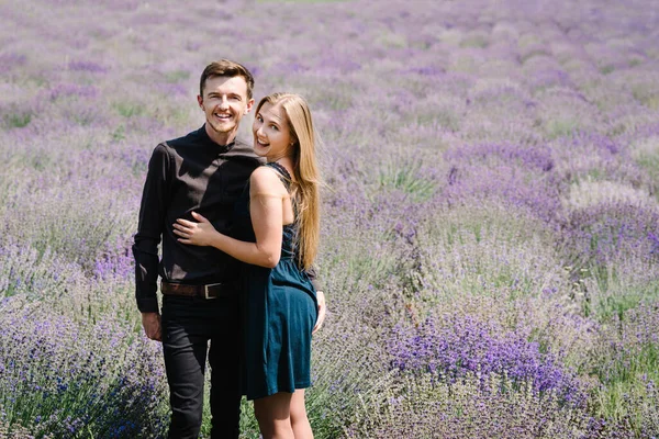 紫色のラベンダー畑での愛の素敵な若いカップルが抱擁し ロマンチックな時間を持っています 男と女が花畑を歩く 新婚旅行だ 幸せなカップル旅行 ラベンダー草原 — ストック写真