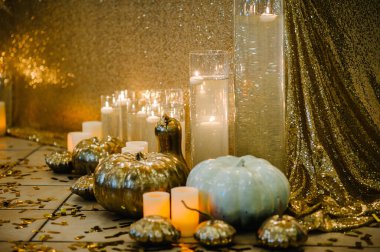 Decorated table for wedding. White balloons, candles, autumn leaves and small pumpkins. Autumn location and Halloween decor. Setting.
