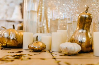 Decorated table for wedding. Candles, autumn leaves, confetti, pumpkins. Autumn location and Halloween decor. Setting.