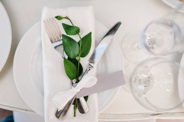 Servis, kurma masası. Tabak ve gümüş çatal bıçak takımı keten peçeteler beyaz kurdeleler ve dallarla süslenmiştir. Düğün masası dekorasyonu. Sanat eserleri. Düz yat. Üst Manzara. Kapat..