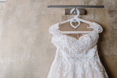 Gelinlik duvarın arkasında asılı duruyor. Kapat..